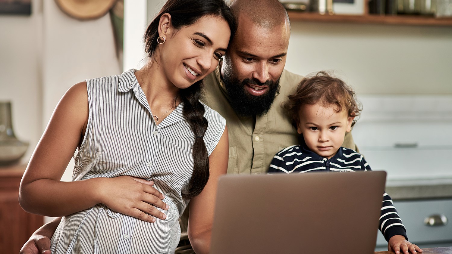 happy young family using a laptop together at home