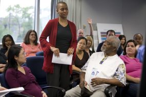 An African American woman attends a town hall meeting conducted on behalf of the ATSDR about local environmental issues. 