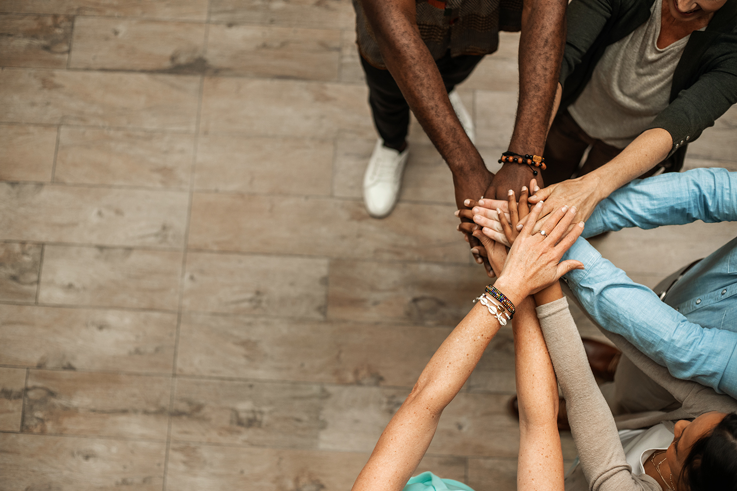 A picture shows diverse human hands placed on top of each