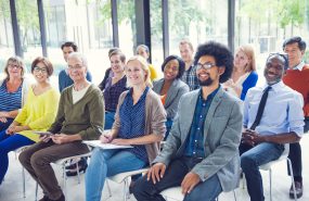 Diverse group of people seated in a seminar.