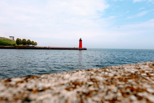 A red lighthouse appears in the distance.