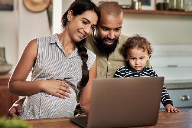 Shot of a happy young family using a laptop together at home.