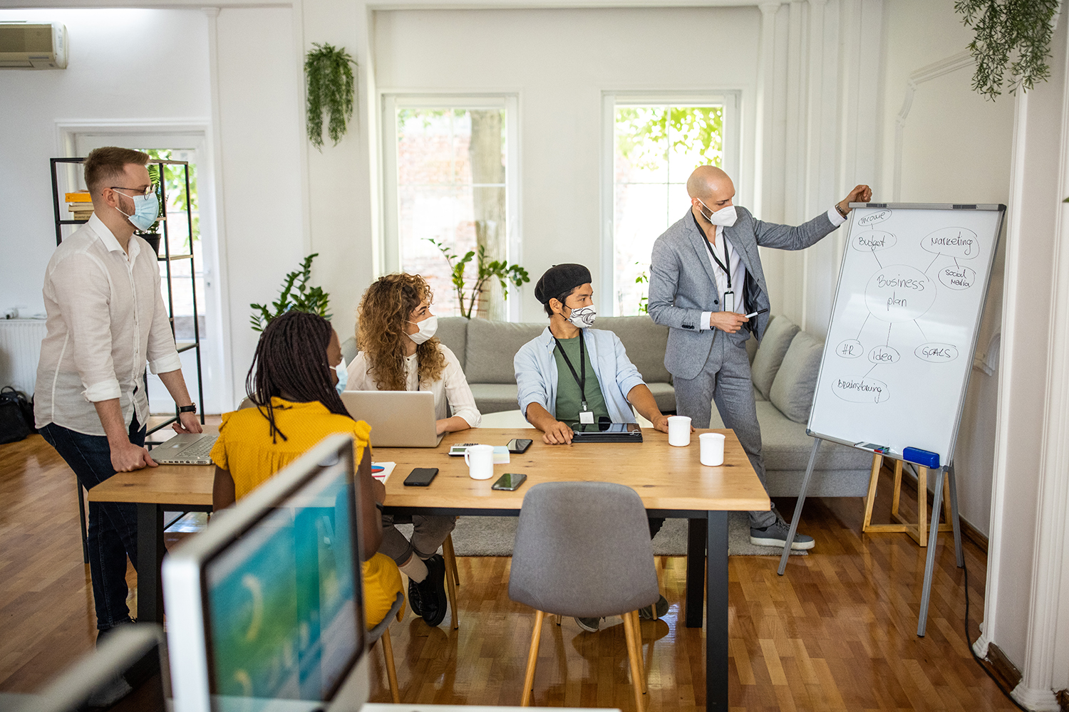 Coworkers talk about business strategy in office meeting.