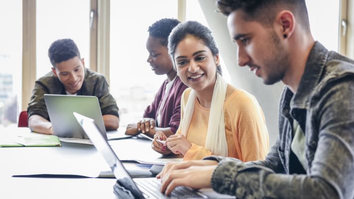 A group of people looking at a computer.