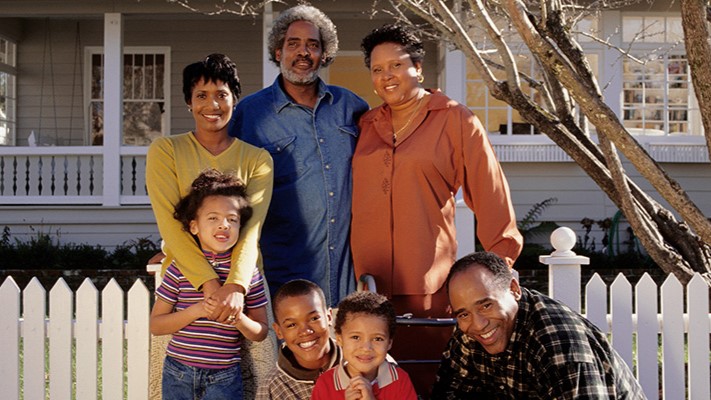 A family posing for a photo in front of their home.