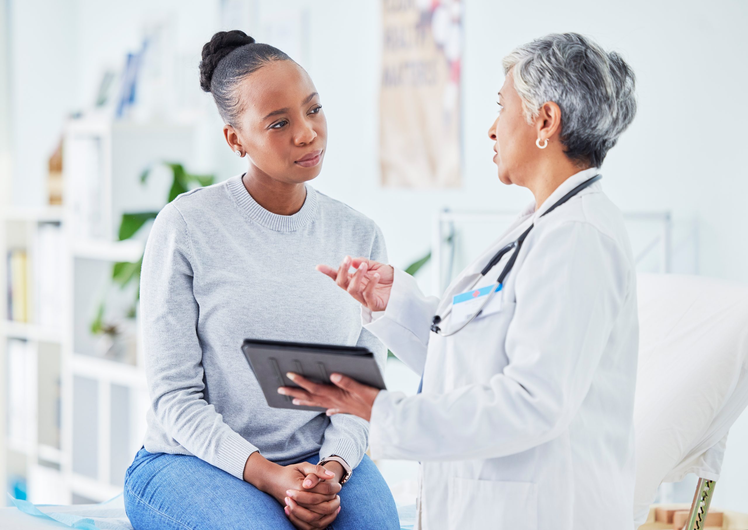 A doctor speaks with a patient in their office.