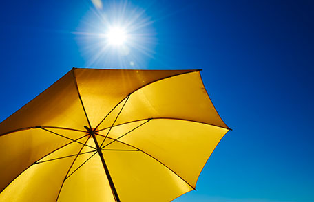 Un paraguas amarillo brillante que proporciona sombra del sol ardiente