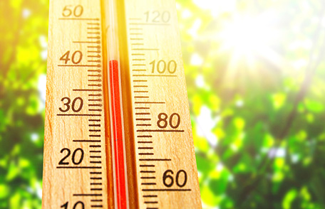 An outdoor thermometer is showing a temperature of over 100 degrees Fahrenheit.
