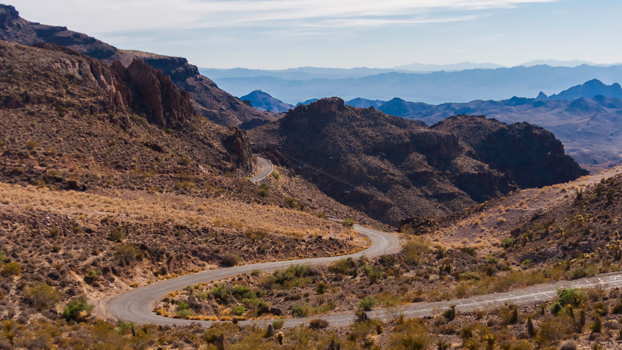 Winding mountain road in rugged, treeless setting.