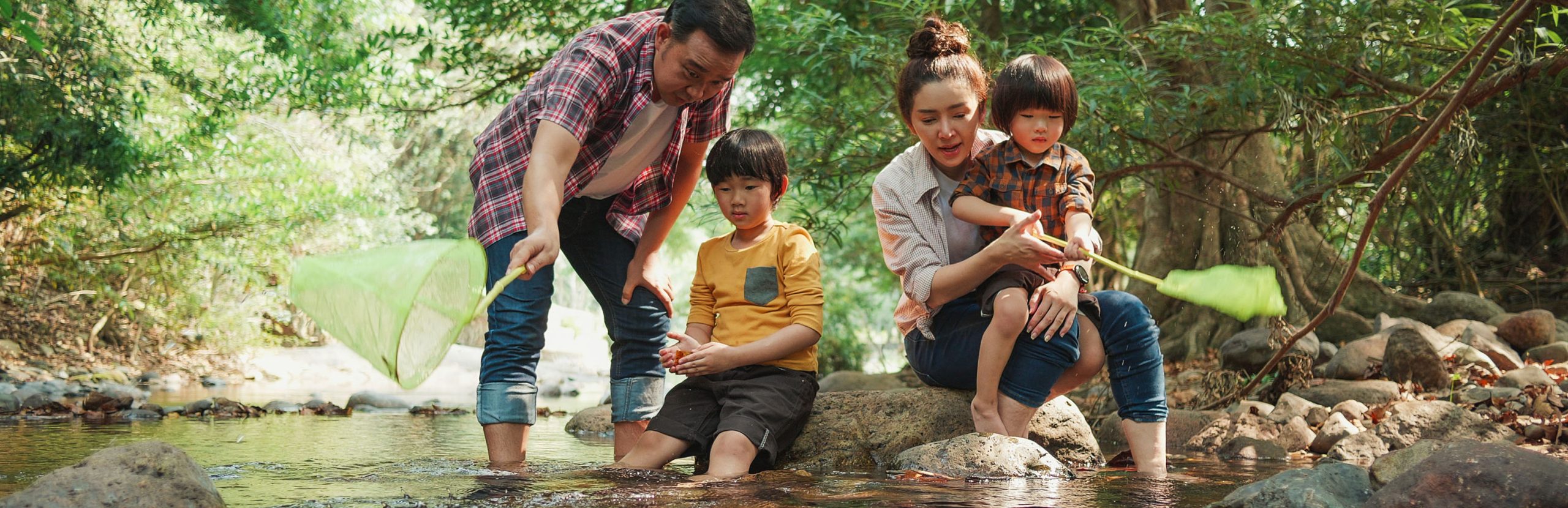 Familia sentados en unas rocas en el rio