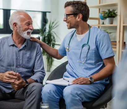 Happy doctor talking to senior male patient