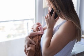 Madre cargando a un bebé recién nacido llamando al doctor