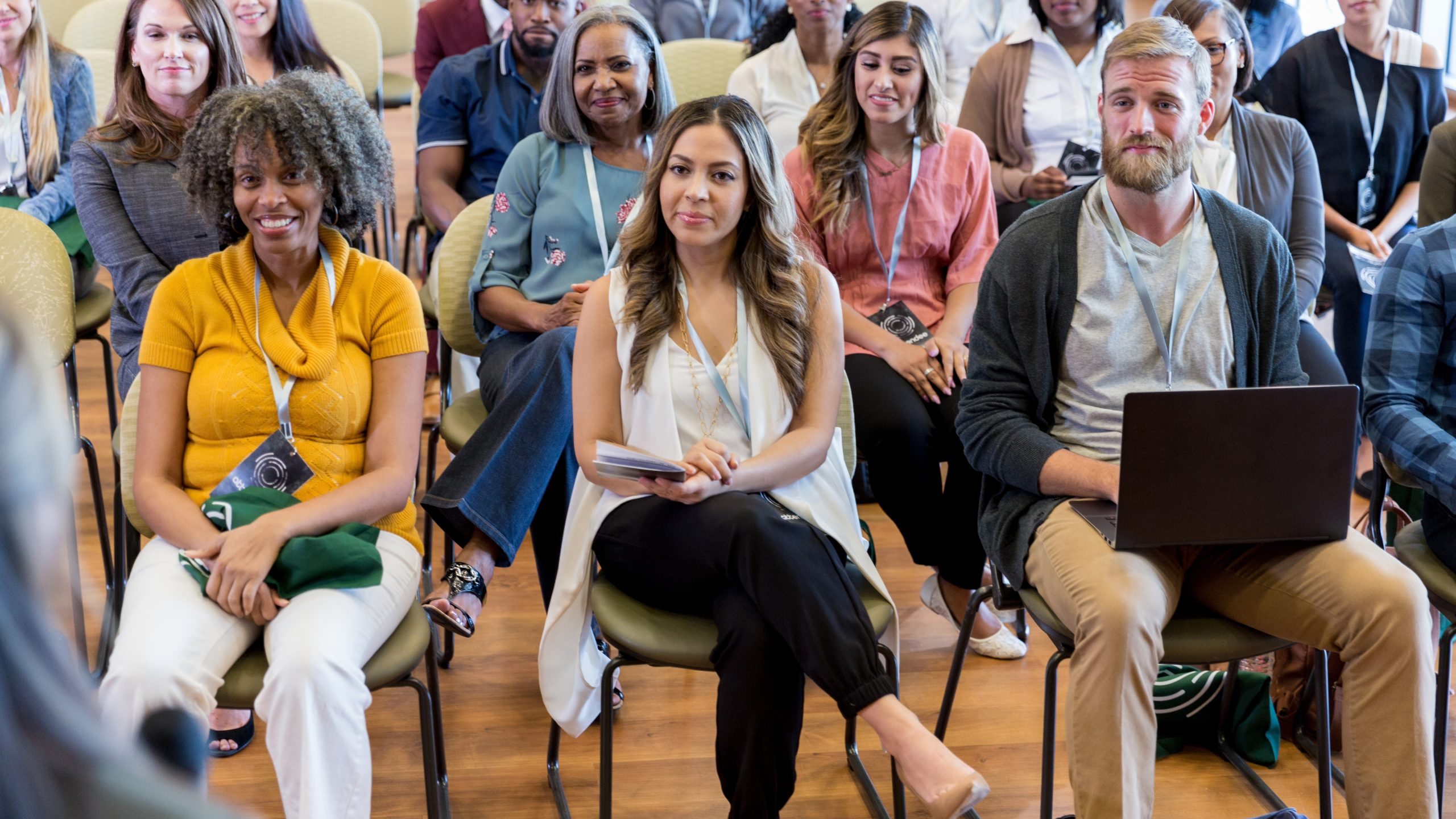 A group of diverse people attending a meeting in a community center.