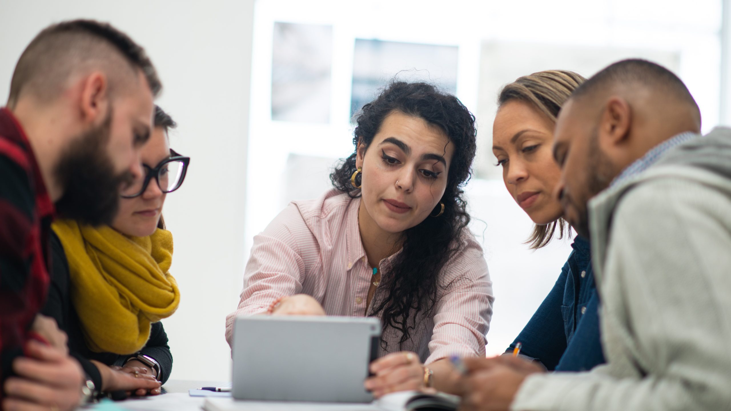 A group of people working together around a laptop