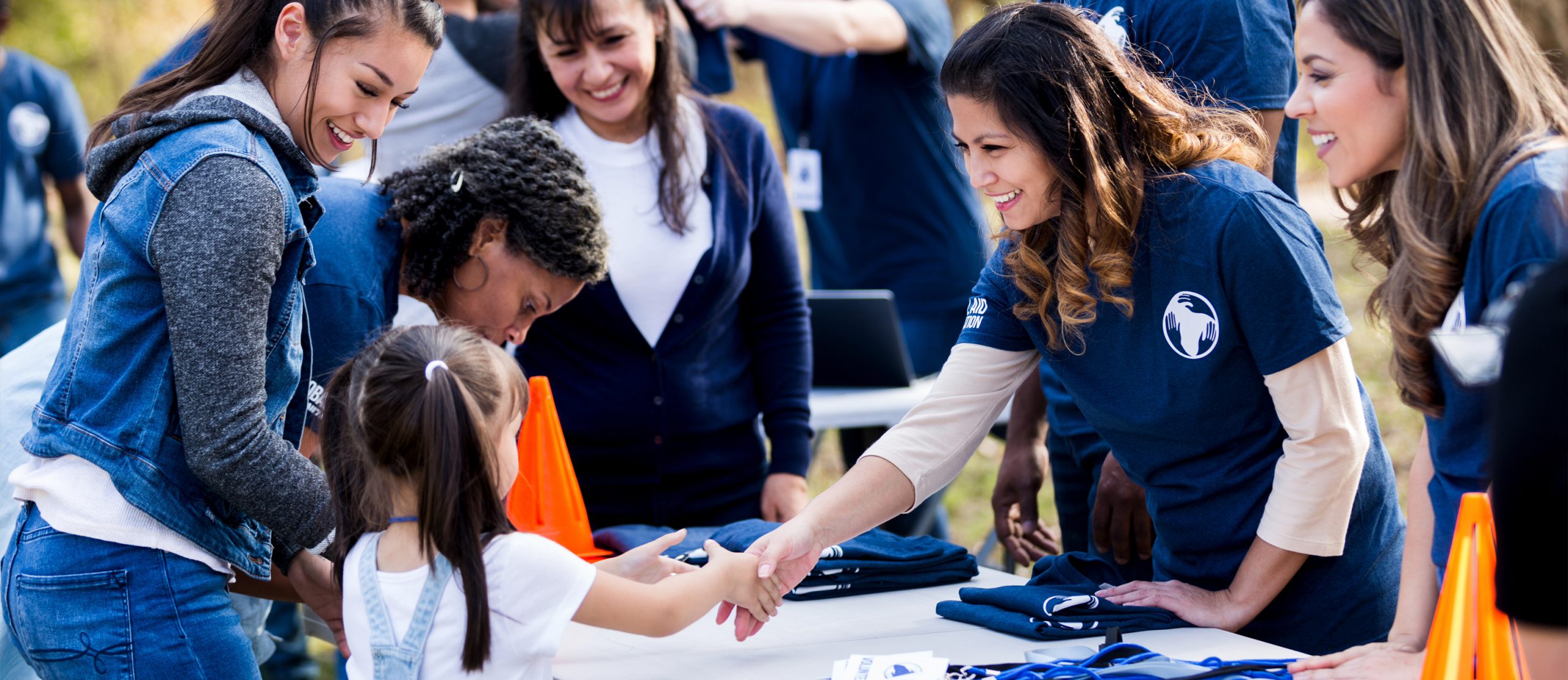 Community event with ladies talking to a young girl.